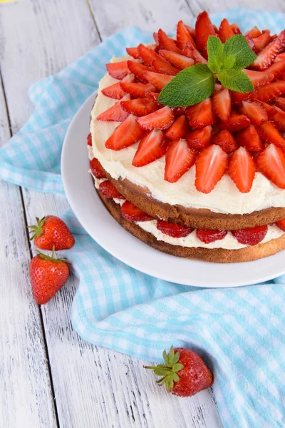 Delicious biscuit cake with strawberries on table close-up — Stock Photo, Image