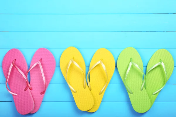 Bright flip flops on wooden background — Stock Photo, Image