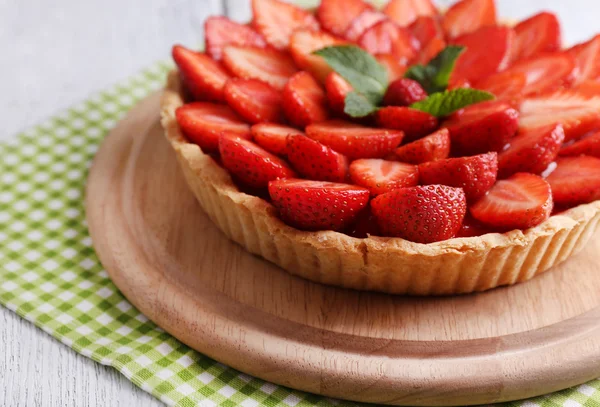 Tarte aux fraises sur plateau en bois, sur fond en bois couleur — Photo