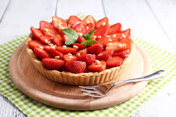 Crostata di fragole su vassoio di legno, su sfondo di legno a colori — Foto Stock