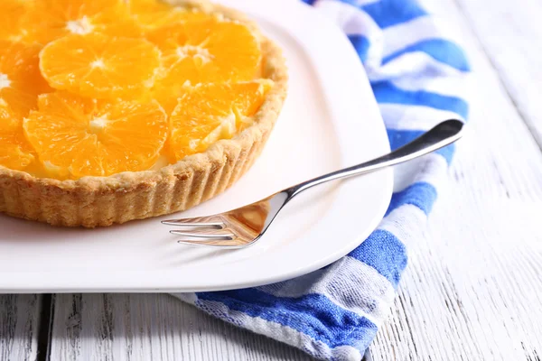 Crostata all'arancia fatta in casa su piatto, su sfondo di legno a colori — Foto Stock