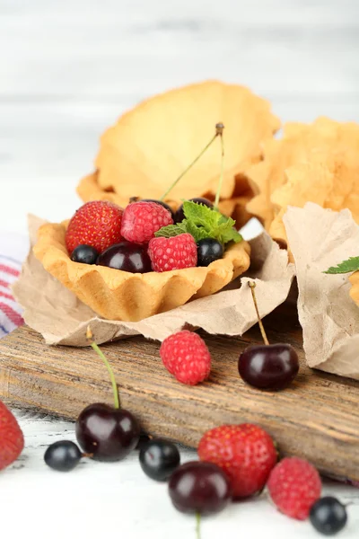 Tasty tartlets with berries on wooden table — Stock Photo, Image