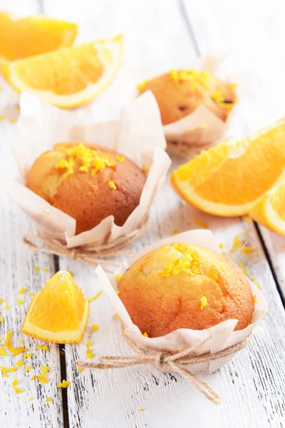 Tasty cupcakes with orange on table close-up — Stock Fotó