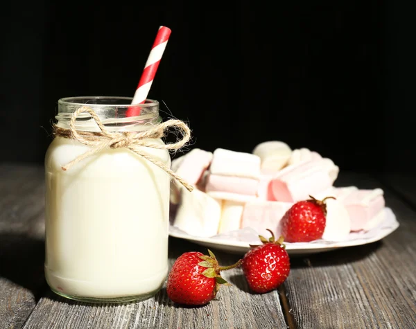 Lait en bouteilles avec des pailles de papier sur la table — Photo