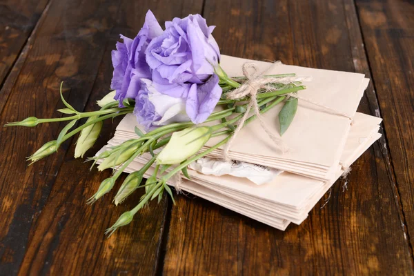 Old letters and flowers on wooden background close-up — Stock Photo, Image