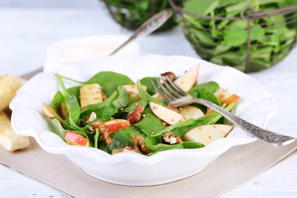 Insalata verde con spinaci, mele, noci e formaggio su fondo chiaro — Foto Stock