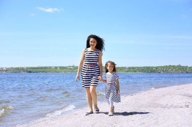 mutlu anne ve kızı. Sahilde yürüyüş