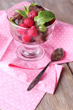 Çikolatalı dondurma nane yaprağı ve olgun çilek rengi ahşap zemin üzerinde cam kase