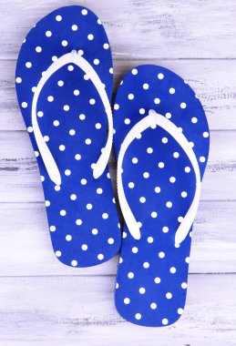 ahşap arka plan üzerinde renkli parmak arası terlik