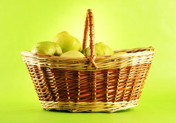 Słodki pigwy w koszyku, na zielonym tle — Zdjęcie stockowe