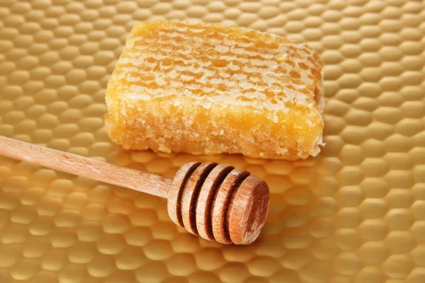 Honey comb and honey on bright yellow background — Stock Photo, Image