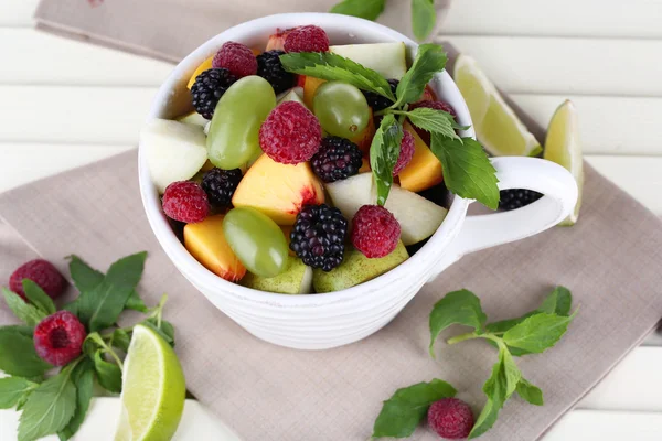 Ensalada de frutas en taza sobre mesa de madera —  Fotos de Stock