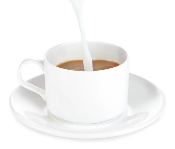 Milk poured into cup of coffee isolated on white — Stock Photo, Image