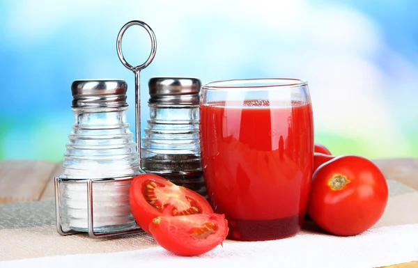 Jugo de tomate en vaso, sobre mesa de madera, sobre fondo brillante — Foto de Stock