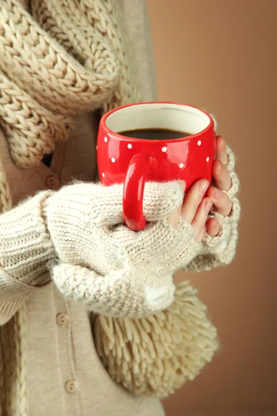Female hands with hot drink, on color background — Stock Photo, Image