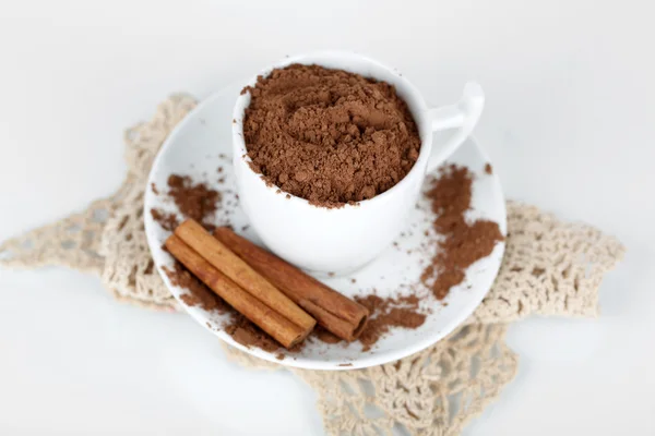 Poudre de cacao en tasse avec soucoupe sur serviette isolée sur blanc — Photo