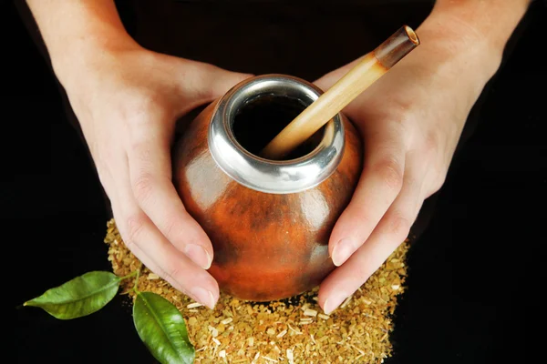 Manos de mujer sosteniendo calabaza y bombilla con yerba mate aislada en negro — Foto de Stock