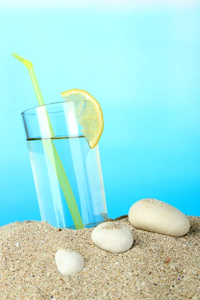 Coquetel de praia na areia no fundo azul — Fotografia de Stock