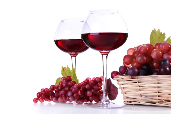 Weingläser mit Rotwein und Trauben im Weidenkorb isoliert auf weiß — Stockfoto