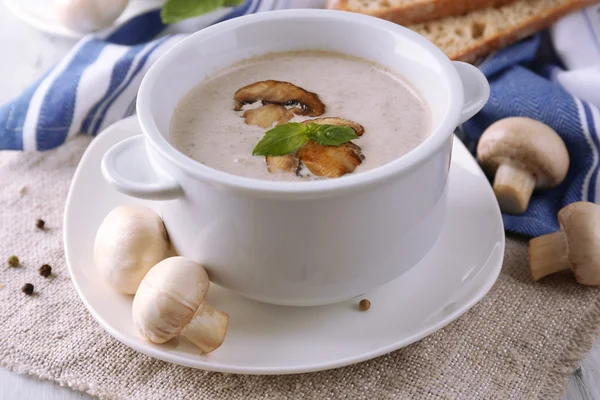 Houbová polévka v bílých květináčích, na ubrousku, na dřevěném pozadí — Stock fotografie
