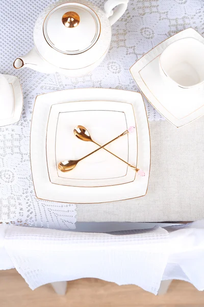 Composizione con teiera, piattino e cucchiai su fondo tavolo in legno — Foto Stock