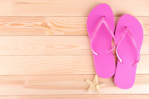 Bright flip-flops on wooden background — Stock Photo, Image