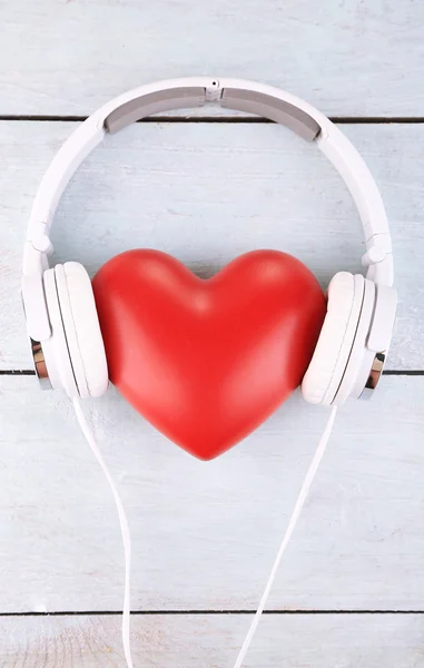 Kulaklık ve ahşap arka plan üzerinde kalp — Stok fotoğraf