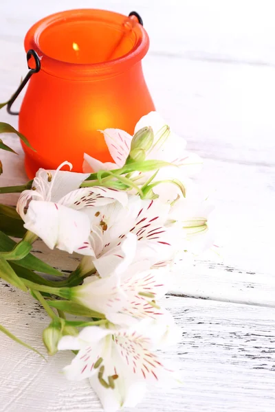 Helle Symbol-Lampe mit Blumen auf hölzernem Hintergrund — Stockfoto