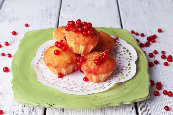Tányéron a színes fából készült háttér piros ribizli bogyókkal finom muffin — Stock Fotó