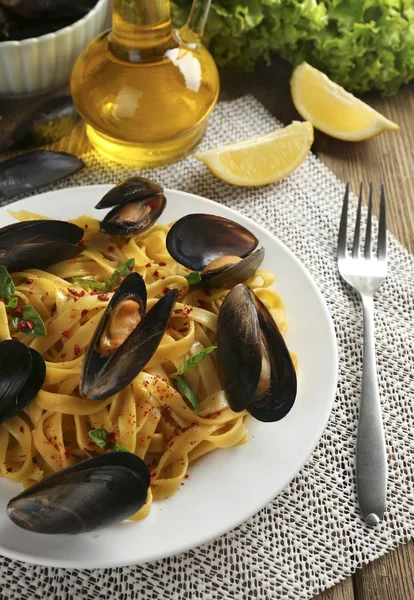 Traditional noodles with mussels on table, close up — Stock Photo, Image