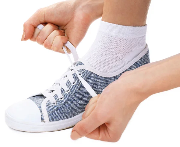 Mujer joven atando cordones aislados en blanco — Foto de Stock