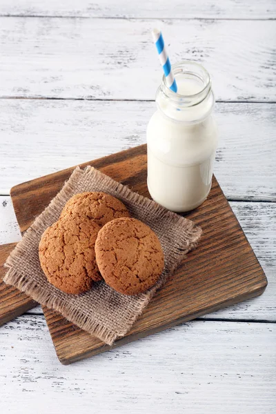 Leche y galletas en mesa de madera —  Fotos de Stock