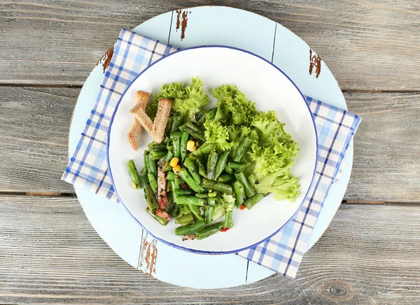 Yeşil fasulye, jambon ve plaka renk ahşap zemin üzerine mısır salatası — Stok fotoğraf