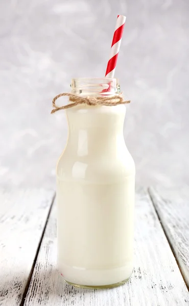 Garrafa de leite na mesa de madeira — Fotografia de Stock