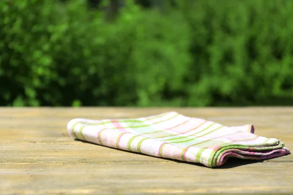 Wooden table with tablecloth, outdoors — Stock Photo, Image