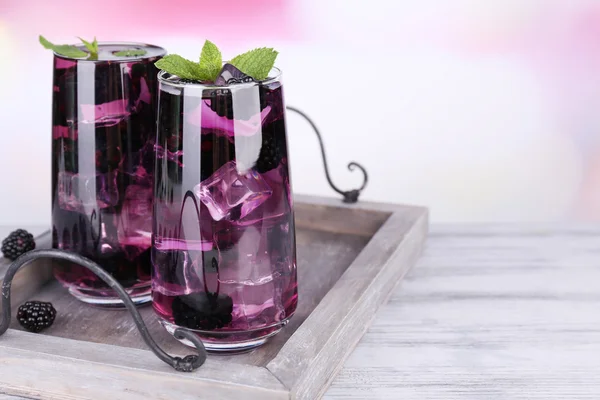 Sabrosa limonada de mora fresca con hielo sobre mesa de madera, sobre fondo claro — Foto de Stock