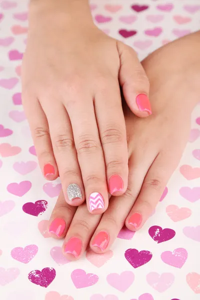 Vrouwelijke hand met stijlvolle kleurrijke nagels, op lichte achtergrond — Stockfoto