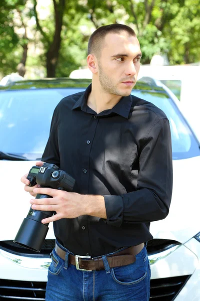 Człowiek w pobliżu samochodu z aparatu fotograficznego — Zdjęcie stockowe