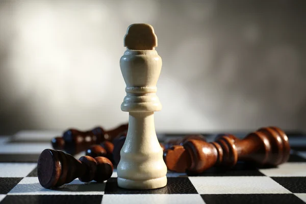 Chess board with chess pieces on grey background — Stock Photo, Image