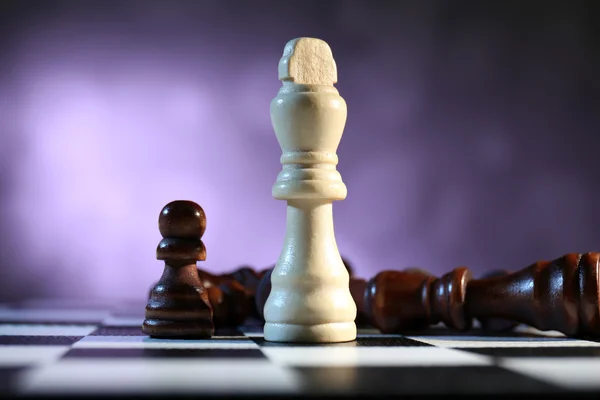 Tablero de ajedrez con piezas de ajedrez sobre fondo morado —  Fotos de Stock