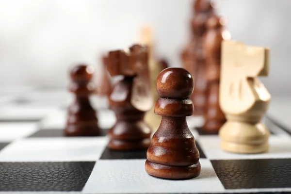 Chess board with chess pieces on grey background — Stock Photo, Image