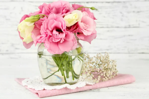 Ramo de flores de eustoma en jarrón sobre fondo de madera — Foto de Stock