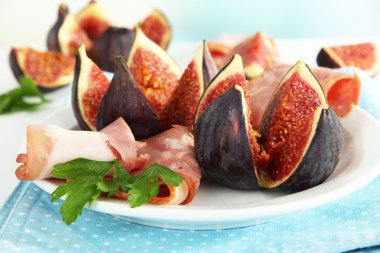 Tasty figs with ham on plate