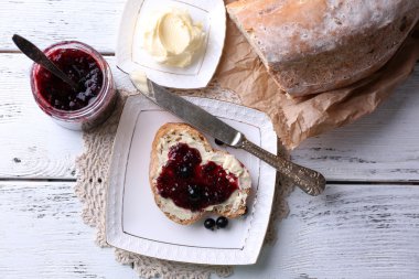 taze ekmek ile ev yapımı tereyağı ve blackcurrant jam hafif ahşap zemin üzerinde plaka üzerinde