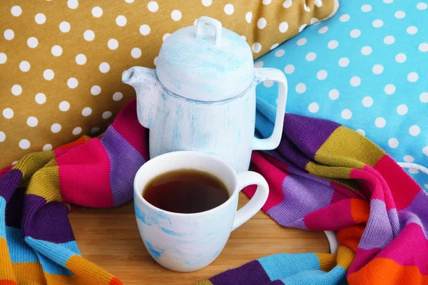 Taza y tetera con bufanda en soporte de madera en la cama de cerca —  Fotos de Stock