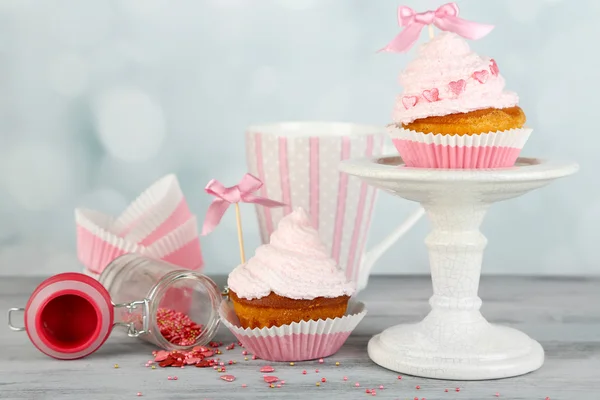 Tasty cup cakes with cream on grey wooden table — Stock Photo, Image