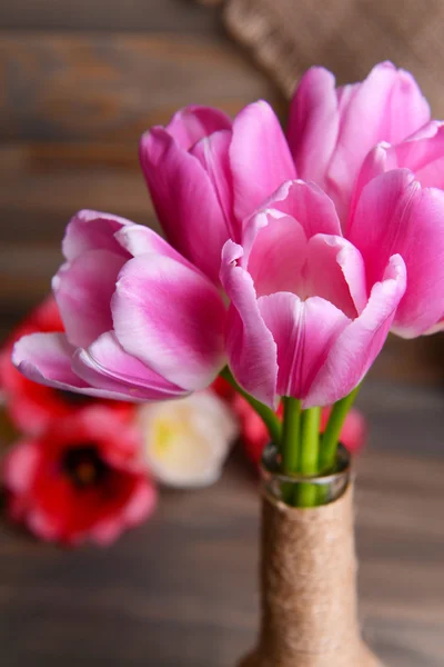 Beautiful tulips in bucket in vase on table on grey background — Stock Photo, Image