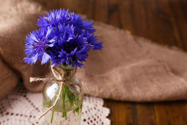 Lindas flores de milho em vaso de vidro em fundo de madeira — Fotografia de Stock