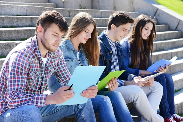 Studenti sedí na schodech v parku — Stock fotografie