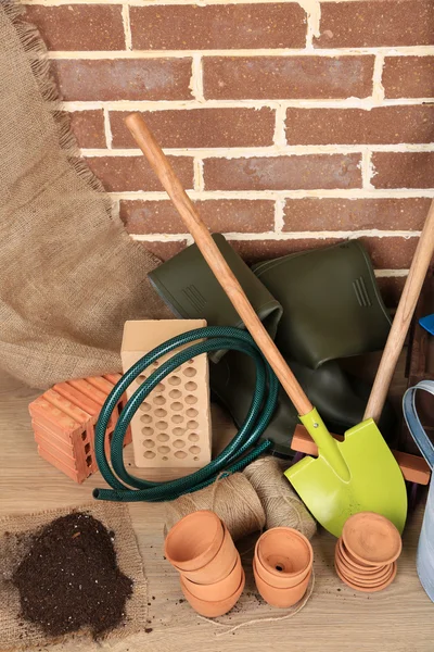 Herramientas de jardinero sobre fondo de ladrillos — Foto de Stock